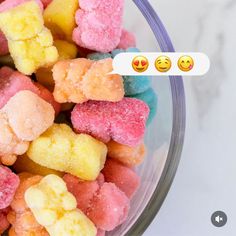 a bowl filled with different colored candies next to an emoticive sticker