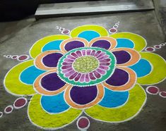 a colorful flower design is painted on the ground