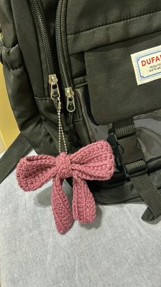 a backpack with a pink bow tied to it