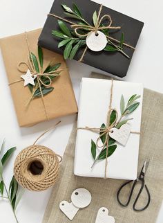 three wrapped presents tied with twine on top of each other, sitting next to some twine