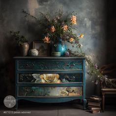 a blue dresser with flowers and vases on top