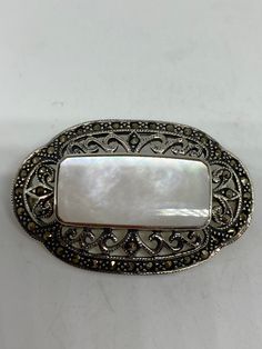 Vintage Pin Marcasite 925 Sterling Silver Brooch Vintage brooch All 925 sterling silver Genuine Marcasite and mother of pearl About 2 inch All jewelry is shipped free in the US in a nice gift box. Check out our over a THOUSAND great reviews Engraving is $4 per letter and is not always perfect depending on the piece. It can take a few days if the jeweler is busy. This is payable to Paypal Judithsltd@gmail.com Elegant Sterling Silver Brooch With Cabochon, White Oval Brooch For Anniversary, Classic Oval Silver Brooches, Elegant Silver Brooches Stamped 925, Wire Wrapped Stone Jewelry, Marcasite Jewelry, Pearl Pin, Sterling Silver Marcasite, Sterling Silver Brooch