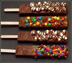 four chocolate candy bars with marshmallows and m & m candies on them