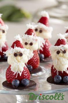 some strawberries with santa clause on them and blueberries in the shape of santa claus