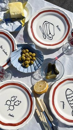 several plates with food on them sitting on top of a white tablecloth covered table