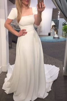 a woman in a white dress taking a selfie