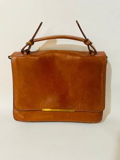 This is a beautiful crossbody purse, inside there is a zipper pocket, two large pockets and a spot for your phone. Also has a detachable, adjustable strap. Note it is missing the closing snap. 10" x 8" x 4" Formal Brown Shoulder Bag With Cell Phone Pocket, Tan Satchel Flap Bag With Adjustable Strap, Vintage Flap Bag For Everyday Use, Classic Crossbody Satchel With Cell Phone Pocket, Vintage Office Satchel With Zipper Closure, Tan Satchel Flap Bag For Everyday Use, Vintage Crossbody Satchel With Zipper Closure, Vintage Tan Satchel For Daily Use, Tan Crossbody Satchel With Detachable Strap