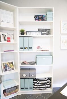 a white book shelf filled with lots of books and other items on top of it