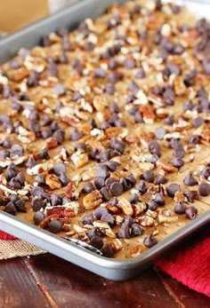 a cookie sheet with chocolate chips and nuts on top