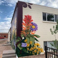 a mural on the side of a building with flowers painted on it's sides