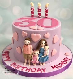 a pink birthday cake with three people and two candles