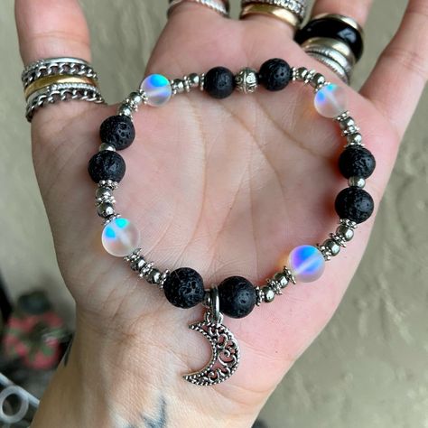 Bead / Gemstone / Boho / Oil Diffuser / Oil Diffusing / Fits 6 To 7.5 Inch Wrist ( If You Need A Different Size Lmk ! ) Handmade By Me Genuine 8mm Oil Diffuser Black Lava Rock Beads . 8mm Opalite Man Made Iridescent Beads (4) . Stainless Steel & Silver Plated Spacers . Silver Plated Dangly Moon Charm / Gift / Stylish , Gems , Trendy , Dainty , Bohemian / Bohochic / Stack Bracelets / Beaded Bracelets / Gemstones / Crecent Moon / Moon Child / Moon Phase . Ceystal Bracelets, Beaded Charm Bracelets Diy, Men Charm Bracelet, Alt Beaded Bracelets, Green Glass Bead Bracelet, Crystal Bead Jewelry Ideas, Beaded Elastic Bracelets, Gothic Beaded Bracelet, Lava Bead Bracelet Ideas