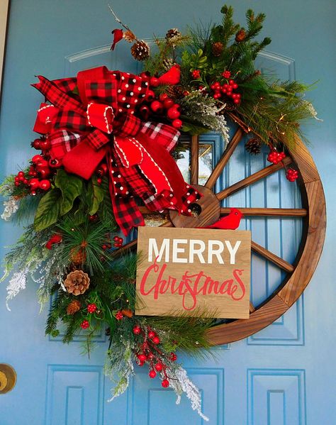 This listing is for a wooden wagon wheel decorated with several types of evergreen branches, pines and firs among them, as well as some snow covered limbs. It also has many differing sizes of red berries. Cardinal birds and pine cones are also plentiful. High end ribbons are used Wheel Christmas Wreath, Christmas Wagon Wheel, Wagon Wheel Ideas, Wagon Wheel Wreath, Christmas Wagon, Wagon Wheel Decor, Outdoor Christmas Tree Decorations, Wheel Wreath, Farmhouse Style Wreath