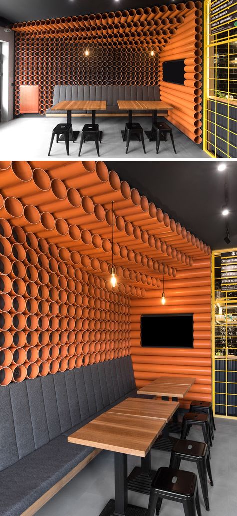 This modern restaurant features almost 300 bright orange PVC pipes that cover the walls and ceilings, while upholstered seating and tables run along the walls, create a comfortable place to sit and eat. #RestaurantDesign #ModernRestaurant #PVCpipes Wall Decoration Restaurant, Wall Design For Restaurant, Restaurant Wall Design, Podcast Room, Restaurant Seating Design, Cafe Uniform, Restaurant Pictures, Retail Fixtures, Restaurant Seating