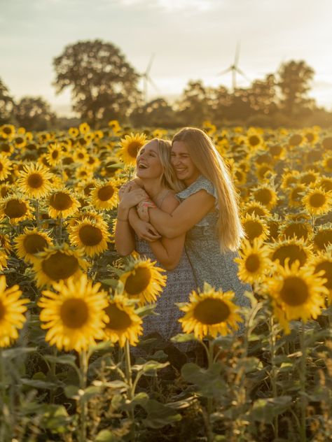 A girl hugging another girl from behind in a sunflower field, both laughing. Fall Sunflower Pictures, Mom And Daughter Sunflower Pictures, Sunflower Field Photoshoot Sisters, Wildflower Picture Poses, Sister Sunflower Photoshoot, Sunflower Field Picture Ideas, Sunflower Field Photoshoot Friends, Best Friend Sunflower Photoshoot, Sunflower Field Photoshoot Poses