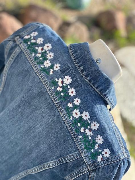 This is a custom embroidered denim jacket. I do this all by hand. There is also an element of heat transfer vinyl so that it makes the embroidery pop a bit. I am happy to make any design you like. Please message me for custom orders. I've washed this kind of jacket many times so it seems that the embroidery holds up very well.  The front of the Jacket does not have any embellishment on it.  If you would like something extra, please include a message so we can collaborate.  The jacket will make a Embroidery On Jean Jackets, Embroidery On Jacket, Denim Embroidery Jacket, How To Style A Denim Jacket, Embroidery Inspiration Clothing, Jean Jacket Embroidery, Embroidery On Jeans, Hand Embroidered Denim, Denim Jacket Embroidery