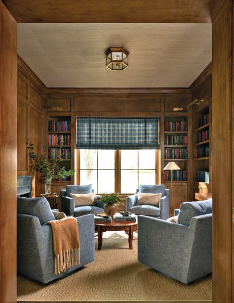 A Stark rug and Schumacher grass-cloth wallcovering on the ceiling warm the richly paneled office, which doubles as an intimate seating area. Thibaut fabric covers custom armchairs while the shade features a Schumacher plaid. A Visual Comfort & Co. flush mount is overhead. Wood Paneled Den, Paneled Den, Katie Davis Design, Katie Davis, Bungalow Interior, Farmhouse Style Table, Wicker Dining Chairs, Ranch Style Home, Luxe Interiors