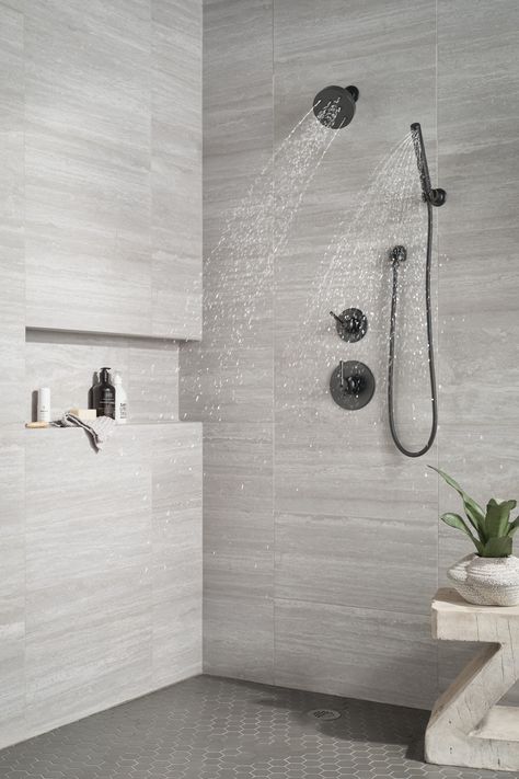 Inspired by the sleek elegance of modern European design, the Trinsic® Bath Collection completes the look of any contemporary bath, from classic to rustic. Delta® H2Okinetic® Showers look different because they are different. Using advanced technology, H2Okinetic showers sculpt water into a unique wave pattern, giving you 3X the coverage of a standard shower head.* The end result is a shower that provides more coverage, more warmth and more intensity for a truly drenching shower experience. Delt Dark Floor Light Shower Tile, Minimalist Bathroom Shower Tile, Corner Seat In Shower Ideas, Showers With Black Fixtures, Modern Walkin Shower Ideas, Black Hardware Shower, Black And White Bathroom Shower Ideas, Grey Tile Showers, Modern Bathrooms Remodel