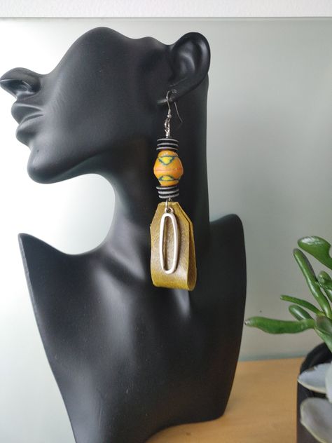 New for fall these funky leather dangle earrings come with levelllllllllls! The base is avocado leather... The neck stacked black and white bone disks with a chunky yellow recycled African krobo bead in the center....  A silver oval dangles from the center...  These earrings bring levels of funk to any outfit .... Denim shirt? Black turtleneck? Yup! Unique Earring Designs, African Style Earrings, Leather Jewelry Making, Bold Statement Jewelry, Outfit Denim, African Earrings, Teal Leather, Fabric Earrings, Earring Trends