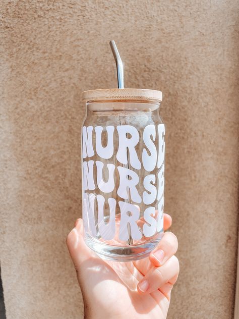 As a nurse or healthcare worker, we LOVE our caffeine. Start enjoying your iced coffee, tea, or water in this glass cup with a design that fits you.  You can order the glass ONLY or the set which includes the glass can, bamboo lid and stainless steel straw. This would make the perfect gift for yourself, a co-worker, friend, or as a birthday or Christmas gift! DETAILS:  * Personalized 16oz glass (with a choice of bamboo lid and stainless steel straw purchased as an add-on)  * I use high quality permanent vinyl for the lettering in your choice of black or white  * Hand wash only (follow care instructions included in packaging)  Feel free to contact me if you're interested in personalizing the cup with a design I don't have, I would love to help make something personalized to you! Nurse Glass Cup Ideas, Nurse Glass Cup, Nurse Cups, Cricket Joy Projects Craft Ideas, Beer Glass Can, Birthday Care Packages, Glassware Design, Bow Template, Nurse Appreciation Gifts