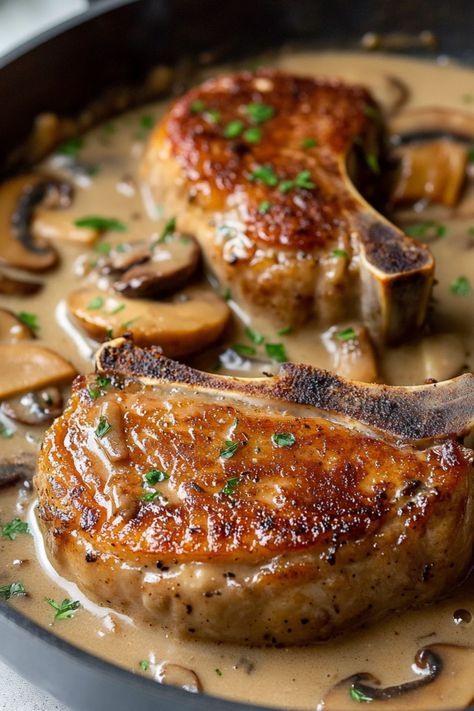 These smothered pork chops with mushroom gravy are such a hearty treat! This one-pan meal is sure to please the entire family. Pork Steaks And Gravy, Pork Tenderloin With Mushroom Gravy, Pork With Mushroom Sauce, Cream Of Mushroom Pork Chops Baked, Smoothed Pork Chops, Smother Pork Chops, Pork Chop Meals, Pork Chops In Mushroom Gravy, Pork And Mushrooms