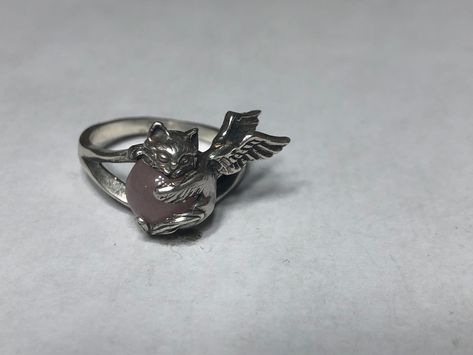 Angel Cat Ring. This cute ring is a sterling silver Angel Kitten with an 8 mm Rose Quartz gemstone.  The Kitty measures 3/4 of an inch (18 mm) across the face and is firmly mounted on a thick shank.  A brand new design;  handmade and hand finished in my studio. The ring pictured is size 8. I will honor any size request up to US size 13 (22.3 mm) same price. The beautiful Brazilian Rose Quartz stone is solidly secured by the paws of this adorable cat. The two wings fit closely to the finger for a Black Cat Ring, Spiky Ring, Weird Rings, Angel Rings, Angel Kitten, Cat Rings, Unique Silver Rings, Cute Ring, Angel Cat