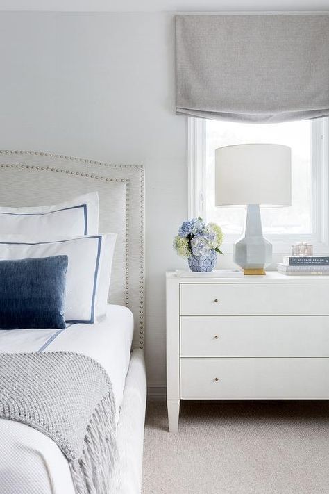 Transitional bedroom boasting a light gray camelback headboard with white and blue bedding beside a white three drawer dresser as a nightstand. Bedroom Arrangement, Grey Headboard, Transitional Bedroom, Bedroom Panel, Blue Bedding, Blue Bedroom, House Room, Photos Ideas, Bedroom Sets