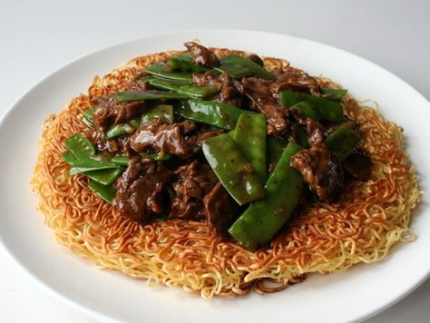 This family favorite is comprised of a crispy bed of golden brown noodles that’s covered with meat, veggies and a velvety gravy. Cake Noodle Recipe, Chinese Pasta, Fresh Egg Noodles, Coco Puffs, Fried Noodles Recipe, Pan Fried Noodles, Fried Noodle, Crispy Noodles, Yummy Bites