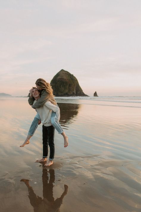 Couple in piggy back pose in front of haystack rock in Oregon. Canon Beach Oregon, Photoshoot Sunset, Canon Beach, Couples Beach Photography, Couple Beach Pictures, Oregon Beach, Beach Photo Session, Travel Pose, Oregon Photography