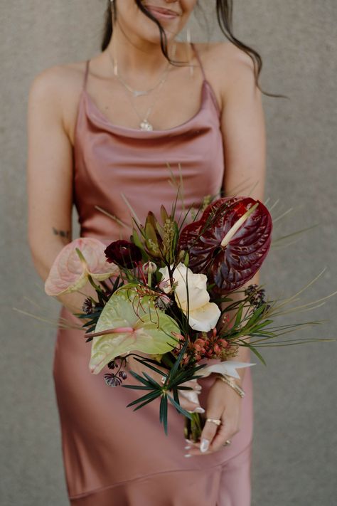 Olive and burgundy tones created a match made in heaven for Alex + Christian’s 1920’s speakeasy hotel themed wedding. Lush tropical potted plants framed their masculine altar, softening Wildman BT’s industrial edges. Sculptural anthurium, spotted orchids, funky ferns, frilly lisianthus, and deep ranunculus made for high-end bridesmaids bouquets and centerpieces. Photographer: Morgan Photo Co Moody Red Florals, Tropical Potted Plants, Moody Wedding Flowers, Bridesmaids Bouquets, Moody Wedding, A Match Made In Heaven, Match Made In Heaven, Made In Heaven, Ranunculus