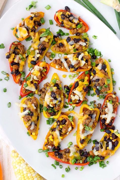 These Taco Stuffed Mini Peppers are the perfect appetizer or light meal! The sweet mini peppers are filled with slightly spicy, taco flavored ground turkey, black beans, and corn for a super fun, low-carb finger food. Taco Stuffed Mini Peppers, Stuffed Mini Sweet Peppers Healthy, Light Mexican Appetizers, Ground Turkey Black Beans, Homemade Appetizers, Black Beans And Corn, Taco Stuffed Peppers, Mini Peppers, Beans And Corn