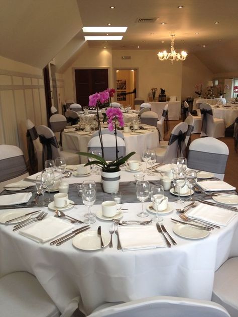 Black and white wedding decor with a flash of hot fuchsia pink by potted orchids centrepieces. - Black organza table runner - Black organza sashes - White Lycra chair covers - Black and White Cupcakes wedding cake with real pink orchid decoration #decoration #wedding #britishwedding #weddingreception #evening #weddingcelebrations #englishwedding #britishweddingplanner #britisheventplanner #cupcakes #weddingcupcakes #cupcakelove #vintage Orchid Centrepiece Wedding, Potted Orchid Centerpiece, Orchid Decoration, Black And White Wedding Decor, Orchid Centerpieces Wedding, Organza Table Runner, Black And White Cupcakes, Orchids Wedding, White Wedding Decor