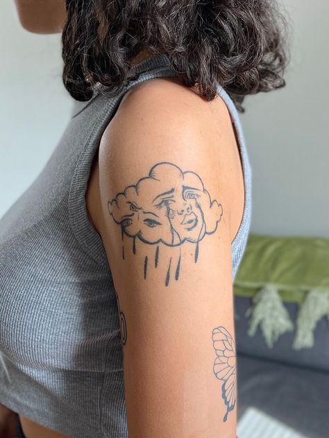 Picture of a crying cloud tattoo on the upper arm Cloud Lady Tattoo, Clouded Head Tattoo, Small Words Tattoo Placement, Upper Arm Tattoo Aesthetic, Arm Tattoo Inspo Aesthetic, Mystic Eye Tattoo, Cloud Tattoo Aesthetic, Cloud With Eyes Tattoo, Cloud With Face Tattoo