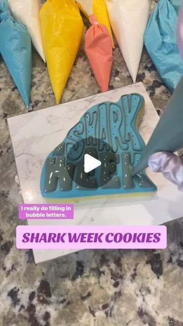 Ashley Marquez on Instagram: "🦈 HOW TO: get puffy icing letters!
• Begin this step when the base icing has crusted but not dried all the way
• poke holes in the base icing (you can see the poke holes) 
• OR use extra thick icing to create “lifts” in the middle of the letters, then fill in with 10 second icing 
• let outlines completely dry (10 minutes) so they really hold their shape 
• fill in with 10 second icing so the icing settles mostly on its own, just needs a little wiggle 
• use the tip of the bag or a scribe to really connect the flood icing to the borders, giving a seamless look
• overfill on wide areas, being careful in tight spots or letters with a hole in the middle - you don’t want the holes to overflow and fill in! 
• dry your icing with a direct fan, immediately. You want Flood Icing, The Flood, Bubble Letters, Royal Icing, All The Way, No Way, Borders, Fan, Canning