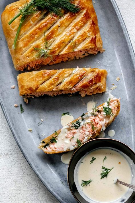 This is a dish worthy of a celebration. Salmon filet is wrapped in buttery, golden brown, flaky, puff pastry, stuffed with creamy spinach, and Boursin cheese, and topped with sprigs of fennel fronds and fresh dill. It's as beautiful as it is delicious and will become a go-to recipe any time you have a special occasion to celebrate. Salmon Puff Pastry Recipes, Salmon Puff Pastry Appetizers, Salmon Puff Pastry, Salmon Wrapped In Puff Pastry, Smoked Salmon Puff Pastry Recipes, Salmon With Puff Pastry, Herb Coated Salmon In Puff Pastry, Salmon In Puff Pastry, Salmon Wellington Recipe