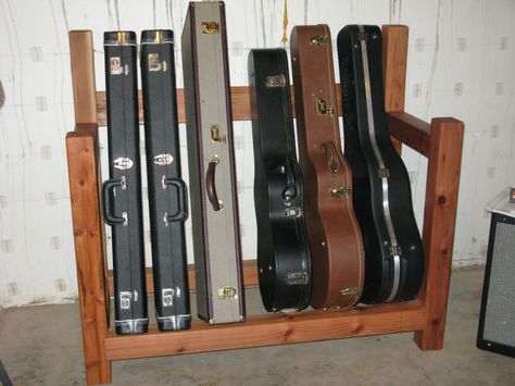 guitar case rack - Woodworking Talk - Woodworkers Forum - I'd like to make something like this, but with an added shelf on top for books. Diy Guitar Case, Guitar Stand Ideas, Violin Storage, Guitar Case Storage, Jewelry Holder Diy, Music Room Storage, Instrument Storage, Guitar Storage, Home Music Rooms