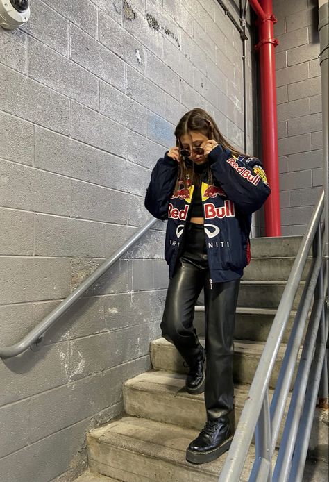 a girl walking down stairs wearing a racing jacket and leather pants Racer Jacket Mini Skirt Outfit, Trendy Fits Summer, Racing Jacket Women Outfit, F1 Race Day Outfit For Women, Motor Cross Jacket Outfit, Redbull Jacket Aesthetic, Street Racing Aesthetic Outfit, Racing Jacket Outfit Women, Formula 1 Women Outfit