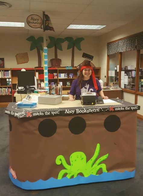 My amazing assistant turned our circulation desk into a pirate ship for our "bookaneer"-themed Book Fair! Pirate Office Decor, Pirate Book Fair, Book Fair Themes, Pirate Office, Gray Library, Book Fair Ideas Display, Library Windows, Purple Pirate, Pirate Theme Classroom