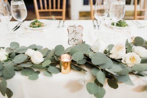 Courtney Inghram Events and Floral Design picture by Alisandra Photography based in Virginia. Trump Winery wedding with silver dollar eucalyptus table garland with white garden roses and mercury glass gold votives.  White and greenery wedding flowers for organic, natural vineyard wedding. Eucaplytus Garland, Eucalyptus White Roses Table Runner, Eucalyptus Runner, Gold Votives, Sweet Heart Table, Greenery Runner, Wedding Table Garland, Scattered Flowers, Heart Table