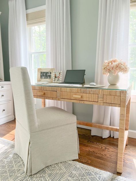 closeup of rattan desk with glass top and computer sitting on top with linen fabric desk chair Fabric Desk Chair, Coastal Bedroom With Desk, Coastal Desk Chair, Rattan Desk Chair, Home Office Coastal, Beachy Desk, Boho Office Room, Coastal Office Decor, Coastal Desk