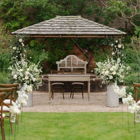 Ceremony set up for Holly & Elliott's wedding with frothy white florals in milk churns, jars of flowers hanging on shepherd hooks lining the aisle and subtle foliage and roses climbing up the pergola 🤍💚 Lovely photographs @scotthowardweddings #ceremony #weddingceremony #classicweddingflowers #whiteandgreen #weddingflorals #simplicity #elegantwedding Jars Of Flowers, Roses Climbing, Classic Wedding Flowers, Milk Churn, Flowers Hanging, White Florals, Wildflower Wedding, Elegant Wedding, Floral Wedding