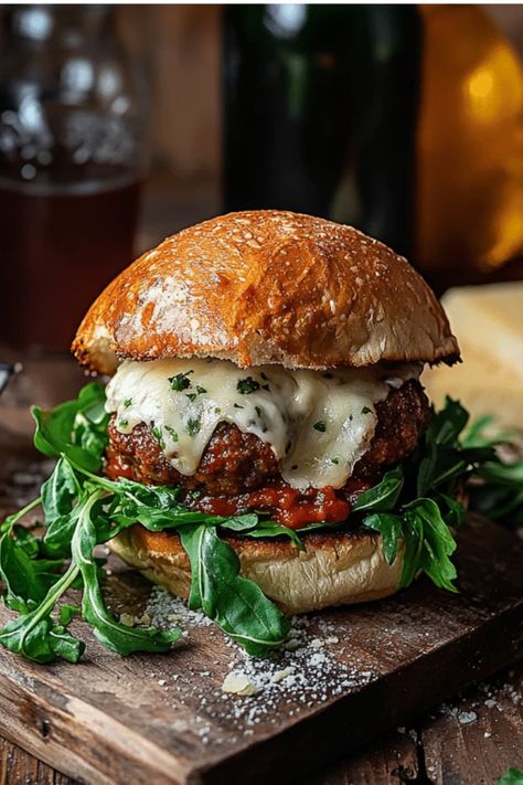 A delicious sandwich featuring Juicy Mozzarella Stuffed Meatball Buns with fresh greens and melted cheese, placed on a rustic wooden board. Meatball Burger, Gourmet Meatballs, Meatball Marinara, Burger Recipes Beef, Italian Meatball, Mozzarella Stuffed Meatballs, Burger Night, Italian Meatballs, Gourmet Burgers