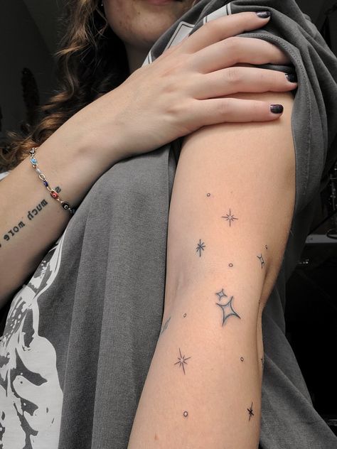 Star tattoo on arm Sparkle Tattoo Sleeve Filler, Star Patchwork Tattoos, Stars Around Moon Tattoo, Scattered Star Tattoos, Thigh Star Tattoo, Star Band Tattoo, Star Hip Tattoos Women, Stars Wrapped Around Arm Tattoo, Twinkle Stars Tattoo