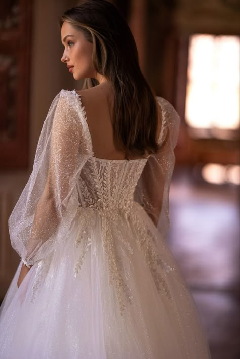 The foundation of the dress is made of mesmerizing glitter fabric, ensuring that the bride will shine and sparkle with every step she takes down the aisle. Delicate floral 3D appliques and pearl beads grace the corset, trailing down in a mesmerizing pattern toward the waistline.
#AriaBride#thenewestcollection#weddingdress2024#clouddress#glitter#a-linedress#weddinggown#longsleeves#collectionMilan Milan Wedding, Elegant Long Sleeve Wedding Dresses, Short Bridal Dress, Bridal Dresses Vintage, Wedding Motifs, Bride Dress Simple, Dreamy Wedding Dress, Sparkle Wedding Dress, Wedding Picture Poses