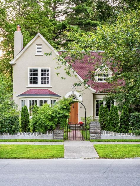 “We love that our stucco house is brighter than traditional Tudors, which often have thick wood beams on the front. We fell for its quaint storybook details, like the stone wall and the brick path,” say Saratoga Springs, New York homeowners Barbara Frank and Rick Guior. Get the look. Hardscaping Ideas, Small Front Yards, Yard Trees, Trees For Front Yard, Sloped Yard, Home Moodboard, Brick Path, Lush Landscaping, Storybook Homes