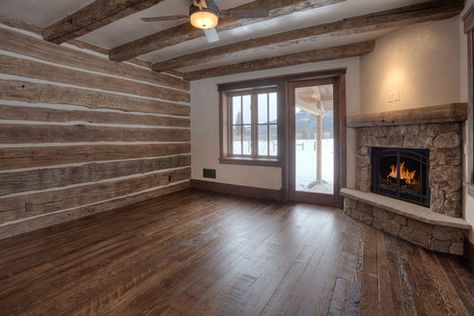 A stone fireplace is nestled in the corner of this "room with a view". a wood chinked bed wall creates variety and wood beams continue the theme. The door opens to an outside private patio with panoramic mountain views. www.timberlineframers.com Chinked Interior Walls, Chinking Interior Walls, Log Siding Interior Walls, Interior Log Walls, Knotty Pine Walls Brick Fireplace, Cedar Walls Interior, White Walls Wood Ceiling Cabin, Faux Cabin Walls, Log Cabin Homes Interior With Drywall