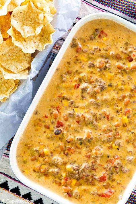 Rotel Dip with ground beef is sure to be a hit at any party! Get the easy stovetop recipe with Rotel tomatoes, ground beef, Velveeta cheese, cream of mushroom soup, ranch style beans, and green chilies. It’s creamy and loaded with flavor. Pour over tortilla chips to make the best nachos! A tasty appetizer dip for game day, Cinco de Mayo, or any fun occasion. #groundbeefrecipes #easyappetizerrecipes #gamedayappetizers Mexican Dip With Ground Beef, Cheesy Hamburger Dip, Ground Beef And Corn, Hamburger Cheese Dips, Dip With Ground Beef, Hamburger Dip, Velveeta Cheese Dip, Recipes With Velveeta Cheese, Chip Dip Recipes