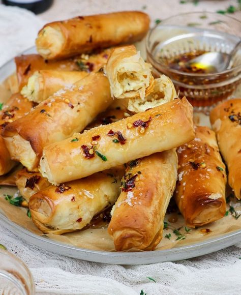 🧀 Fried Feta Rolls Crispy Phyllo Rolls Filled with Creamy Feta Cheese and Drizzled with Honey Ingredients: 8 oz block of feta cheese, cut into sticks 8 sheets phyllo dough, thawed 1/4 cup olive oil or melted butter 1/4 cup honey 1 tablespoon sesame seeds (optional) Fresh thyme or rosemary (optional for garnish) Directions: Prepare the Phyllo Dough: Lay one sheet of phyllo dough on a clean, dry surface. Brush lightly with olive oil or melted butter. Place another sheet on top and brush again... Fried Feta Rolls, Honey Feta, Phyllo Rolls, Feta Rolls, Fried Feta, Chili Honey, Creamy Feta, Phyllo Dough, Fresh Thyme