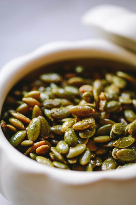 Close-up of roasted pepitas in a white ceramic dish. Pepitas Salad, Toasted Pepitas, Roasted Pepitas, Shelled Pumpkin Seeds, Easy To Make Snacks, Edible Seeds, Seed Bread, How To Roast, Pumpkin Spice Syrup