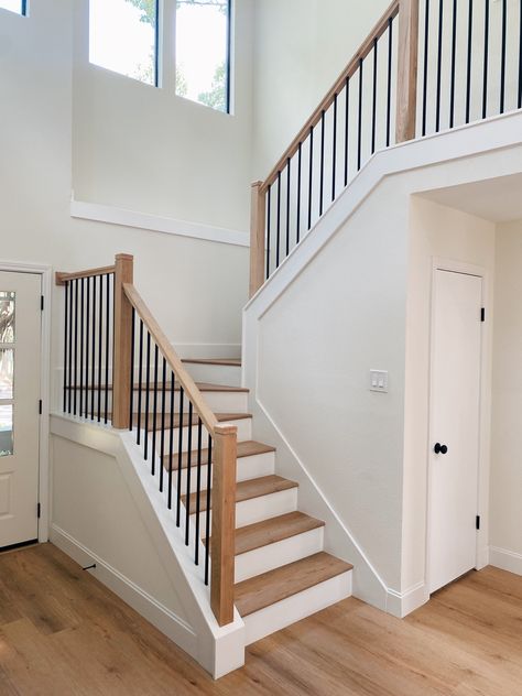 Modern Farmhouse Wrought Iron Staircase. Wood Stairs Iron Railing, Family Room With Staircase, Dark Railing Light Floor, Add Railing To Stairs, Farmhouse Spindles Stairs, Rambler Staircase, Wood Stair Railing Ideas Modern, Closed Tread Staircase, Banister Spindles Ideas